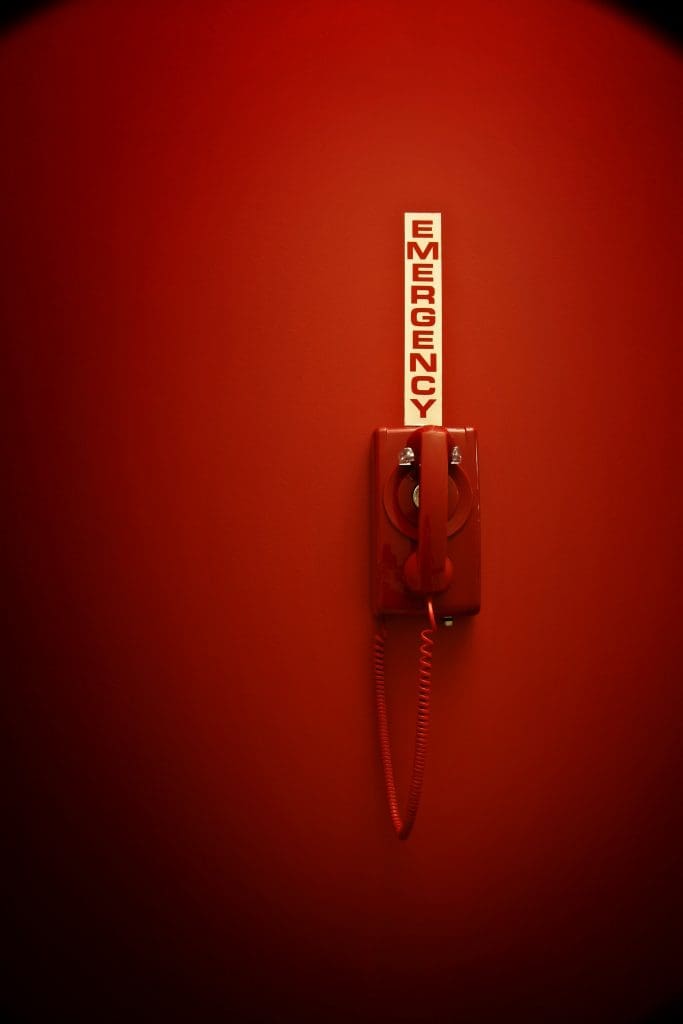 Red telephone with emergency sign.