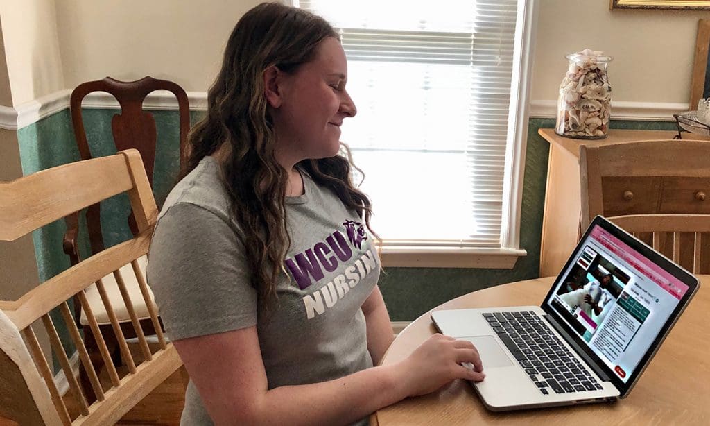 Nursing student sits at laptop