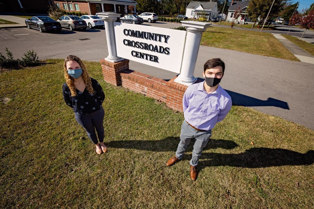 Schweitzer Fellows stand in front of a sign for the Community Crossroads Center